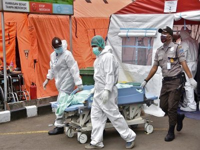 Des soignants transportent le corps d'un  malade décédé du Covid-19 dans un hôpital de Bekasi, en Indonésie, le 1er juillet 2021 - Rezas [AFP]