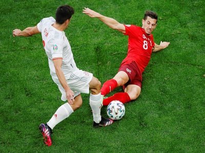 Le milieu de terrain suisse Remo Freuler tacle l'attaquant espagnol Gerard Moreno, lors de leur quart de finale de l'Euro 2020, le 2 juillet 2021 à Saint-Petersbourg - ANTON VAGANOV [POOL/AFP]
