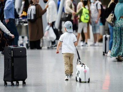 Un enfant tire sa valise dans le hall d'embarquement de l'aéroport de Düsseldorf, le 2 juillet 2021 en Allemagne - Ina FASSBENDER [AFP]