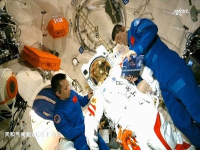 Les astronautes chinois Tang Hongbo (G) et Liu Boming (D) le 23 juin 2021 à bord de la station spatiale Tiangong, avec la combinaison qu'ils ont utilisée le 4 juillet pour sortir dans l'espace - - [CCTV/AFP]