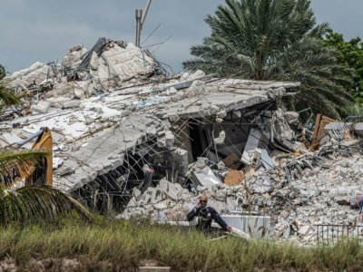 Des secouristes venus de tous les Etats-Unis, du Mexique et d'Israël s'affairent sur les décombres d'un immeuble effondré en Floride onze jours plus tôt, le 6 juillet 2021 - Giorgio VIERA [AFP]