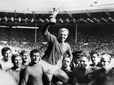 Le capitaine de l'équipe d'Angleterre, Bobby Moore, porté par ses coéquipiers, brandit le trophée de la Coupe du monde,  après la victoire de son équipe (4-2 en prolongation), en finale, le 30 juillet 1966 au stade de Wembley à Londres - - [CENTRAL PRESS/AFP/Archives]