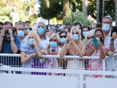 Des personnes masquées attentent l'arrivée de l'équipe du film "Benedetta", le 9 juillet 2021 à Cannes - Valery HACHE [AFP]
