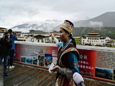 Une guide montre le village touristique de Lunang, à Nyingtri, dans la région autonome chinoise du Tibet, durant une visite de presse le 2 juin 2021 - Hector RETAMAL [AFP]