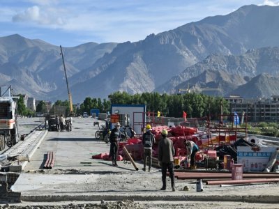 Des ouvriers construisent une route à Lhassa dans la région autonome du Tibet, le 2 juin 2021 - Hector RETAMAL [AFP]