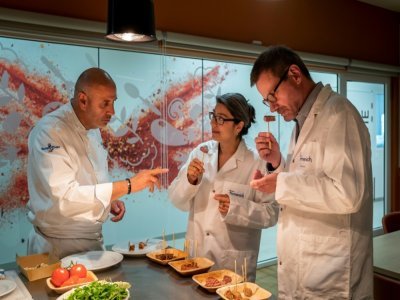 Le chef Nicolas Maire (g) et les spécialistes du goût Liliana Favaron (c) et Mark Rubin goûtent un steak végétal au siège de la société suisse Firmenich à Satigny, près de Genève, le 30 juin 2021 - Fabrice COFFRINI [AFP]