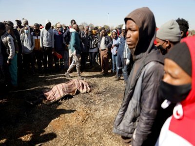 Foule réunie autour du corp d'un jeune homme à Vosloorus, dans la banlieue de Johannesbourg, en Afrique du Sud, le 14 juillet 2021 - Guillem SARTORIO [AFP]