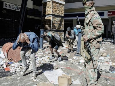 Pillards arrêtés par la police et l'armée sud-africaines devant un centre commercial à Soweto, en banlieue de Johannesbourg, le 13 juillet 2021 - LUCA SOLA [AFP]