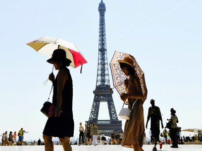Photo d'illustration montrant des touristes marchant devant la Tour Eiffel, le 3 août 2018 - ALAIN JOCARD [AFP/Archives]