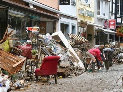 Des habitants de Bad Neuenahr-Ahrweiler (Allemagne) nettoient les débris après des inondations catastrophiques le 16 juillet 2021 - Christof STACHE [AFP]