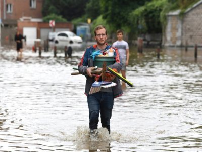 Un habitant dans une rue inondée d'Angleur, près de Liège, le 16 juillet 2021 - JOHN THYS [AFP]