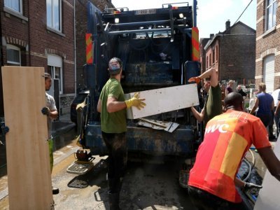 Des habitants jettent des meubles abîmés par les inondations à Angleur, près de Liège, le 17 juillet 2021 - François WALSCHAERTS [AFP]