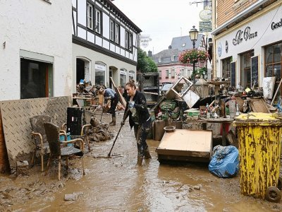 Un habitant enlève la boue pour dégager une rue à Bad Neuenahr-Ahrweiler, en Allemagne, le 16 juillet 2021 - CHRISTOF STACHE [AFP]