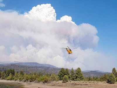 Un hélicoptère chargé d'eau vole près du Bootleg Fire, dans l'Oregon, le 15 juillet 2021 - Payton Bruni [AFP]