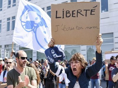 Une femme tient une pancarte sur laquelle on peut lire "Liberté, j'écris ton nom" lors d'une manifestation contre les nouvelles mesures de sécurité contre le coronavirus, , à Nantes, dans l'ouest de la France, le 17 juillet 2021. - Sebastien SALOM-GOMIS [AFP]