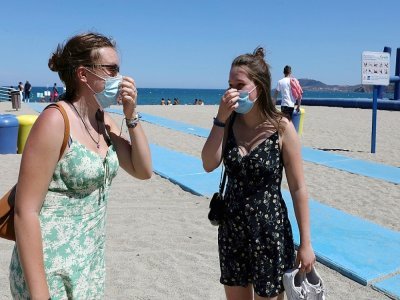 Deux femmes remettent leur masque en revenant de la plage - même s'il n'est pas obligatoire - à Argeles-sur-Mer (sud de la France), le 17 juillet 2021 - RAYMOND ROIG [AFP]