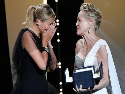 La réalisatrice Julia Ducournau, émue, reçoit la Palme d'or, remise par Sharon Stone (d), pour son film "Titane", le 17 juillet 2021 au Festival de Cannes - CHRISTOPHE SIMON [AFP]