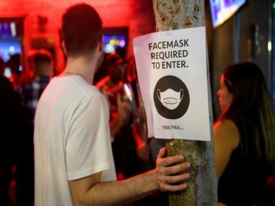 Une affiche annonce l'obligation de porter le masque pour rentrer à l'intérieur d'un bar, à West Hollywood, près de Los Angeles, le 18 juillet 2021 - Patrick T. FALLON [AFP]