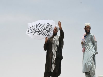 Un homme tient le drapeau taliban au côté afghan du point de passage de Chaman, le 17 juillet 2021 à la frontière avec le Pakistan - Banaras KHAN [AFP]