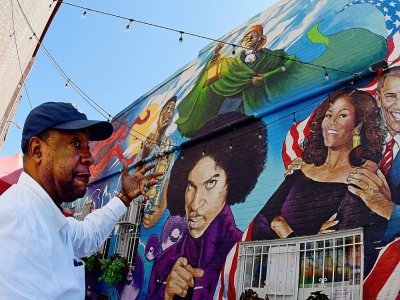 Furard Tate, co-fondateur de DMV Black Restaurant Week, devant une peinture murale à Washington, le 29 juin 2021 - Eva HAMBACH [AFP]