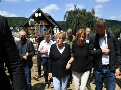 La chancelière allemande Angela Merkel (c) dans le village de Schuld, ravagé par 
les inondations, près de Bad Neuenahr-Ahrweiler, le 18 juillet 2021 en Allemagne - Christof STACHE [POOL/AFP]