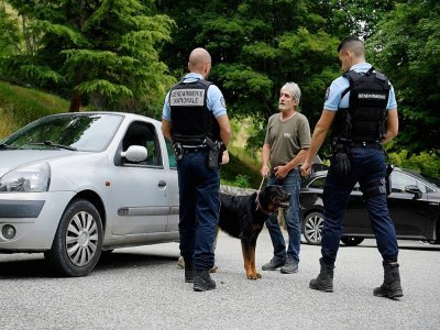 Des gendarmes en discussion avec un habitant du village de Gréolières, le 19 juillet 2021, lors de la traque d'un homme soupçonné de féminicide - Nicolas TUCAT [AFP]