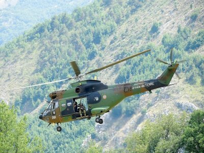 Un hélicoptère Puma de l'Armée de l'air survole le village de Gréolières dans les Alpes Maritimes, le 19 juillet 2021, pour retrouver un homme en fuite soupconné de féminicide - Nicolas TUCAT [AFP]