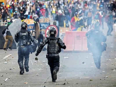 Des manifestants face à des policiers anti-émeutes à Cali (Colombie), le 20 juillet 2021 - Paola MAFLA [AFP]