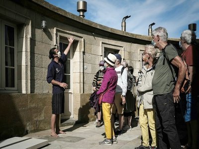 Le gardien Thomas Dalisson explique le fonctionnement du phare du Cordouan à des visiteurs, le 10 juin 2021 au Verdon-sur-Mer, en Gironde - Philippe LOPEZ [AFP]