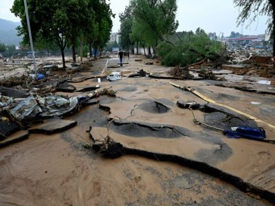 La population constate les dégâts après les intempéries à Mihe, dans la province du Henan (centre de la Chine), le 22 juillet 2022 - JADE GAO [AFP]