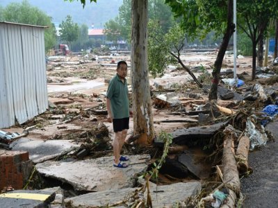 Un homme constate les dégâts après les intempéries à Mihe, dans la province du Henan (centre de la Chine), le 22 juillet 2022 - JADE GAO [AFP]