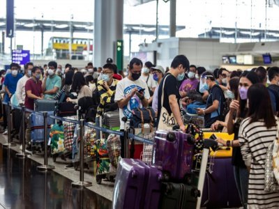 Des habitants attendent pour s'enregistrer sur un vol pour la Grande-Bretagne à l'aéroport de Hong Kong le 19 juillet 2021 - ISAAC LAWRENCE [AFP]