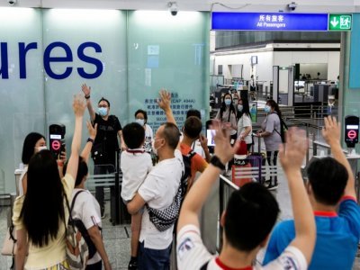 Adieux avant l'embarquement sur un vol pour le Royaume-Uni à l'aéroport de Hong Kong le 19 juillet 2021 - ISAAC LAWRENCE [AFP]