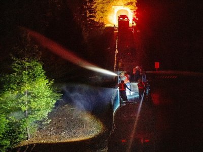 Des pompiers à bord d'un train arrosent de la végétation, près des flammes du Dixie fire, le 25 juillet 2021 - JOSH EDELSON [AFP]