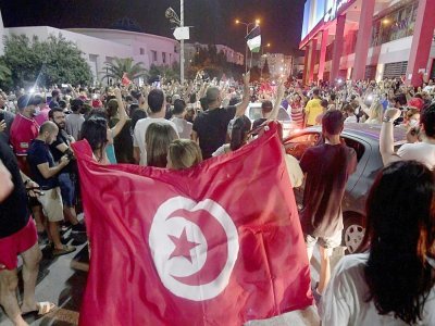 La foule célèbre dans la rue après la décision du président tunisien Kais Saied de geler les travaux du Parlement pour 30 jours et de s'octroyer le pouvoir exécutif, le 25 juillet 2021 à Tunis - FETHI BELAID [AFP]