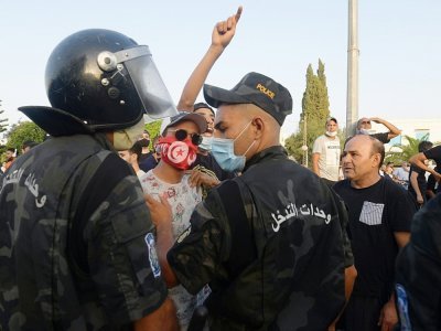 Des forces de sécurité séparent des partisans du président Kais Saied et ceux du parti Ennahdha, devant le Parlement bloqué par l'armée, à Tunis le 26 juillet 2021 - FETHI BELAID [AFP]