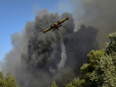 Un avion largue de l'eau sur un feu de forêt à Labiri, près de Patras (Grèce), le 31 juillet 2021 - STR [Eurokinissi/AFP]