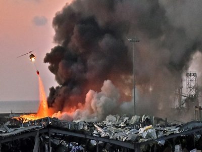 Un hélicoptère aide à éteindre le feu après l'explosion au port de Beyrouth, le 4 août 2020 - STR [AFP/Archives]