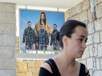 L'époux, le frère et le cousin de Karlen Hitti Karam, montrés dans une photo derrière la jeune femme qui les a perdus tous trois -des pompiers- dans l'explosion du 4 août 2020 au port de Beyrouth - JOSEPH EID [AFP/Archives]
