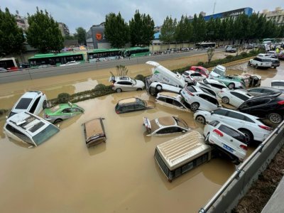 Des voitures dans une voie de circulation inondée de Zhengzhou en Chine, le 21 juillet 2021 - STR [AFP/Archives]