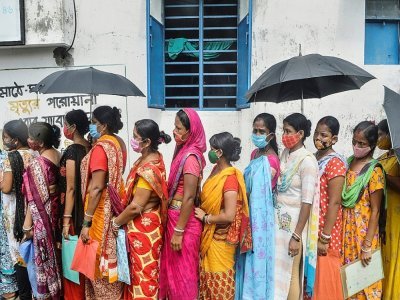 Des femmes font la queue pour recevoir un vaccin contre le coronavirus devant un centre médical de Siliguri (Inde), le 2 août 2021 - Diptendu DUTTA [AFP]