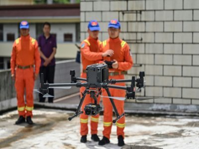 Des gardes forestiers du Yunnan manipulent un drone chargé de surveiller la migation des éléphants, le 23 juillet 2021 - Hector RETAMAL [AFP]