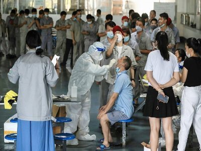 Centre de test Covid-19 dans le réfectoire d'une usine automobile le 4 août 2021 à Wuhan, en Chine, épicentre de l'épidémie en 2019 - STR [AFP]