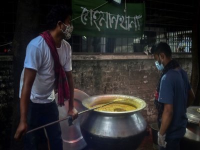 Des volontaires de l'association Mehmankhana préparent un repas pour les personnes affectées par la crise du coronavirus, le 26 juillet 2021 à Dacca - Munir Uz zaman [AFP]