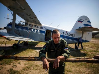 Vladimir Stroyev, pilote du Service aérien de protection des forêts, se repose après un vol d'observation au-dessus des feux de forêt à l'extérieur du village de Berdigestyakh en Sibérie - Dimitar DILKOFF [AFP]