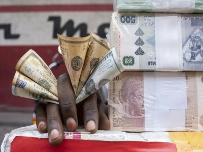 Un cambiste montre des francs congolais sur un marché de Kinshasa, le 11 août 2021 en RDC - Arsene MPIANA [AFP]