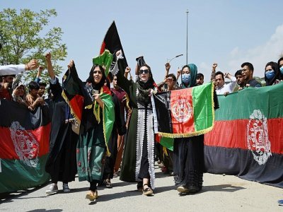 Des Afghans célèbrent le 102e anniversaire de l'indépendance de l'Afghanistan en brandissant le drapeau national, à Kaboul le 19 août 2021 - WAKIL KOHSAR [AFP]