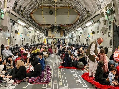 Des Afghans s'installent dans un avion militaire américain qui va les évacuer d'Afghanistan, à l'aéroport de Kaboul, le 19 août 2021 - Shakib RAHMANI [AFP]