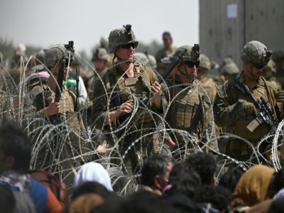 Des soldats américains derrière des barbelés à l'aéroport militaire de Kaboul où se pressent des Afghans qui tentent de fuir le pays, le 20 août2021 - Wakil KOHSAR [AFP]