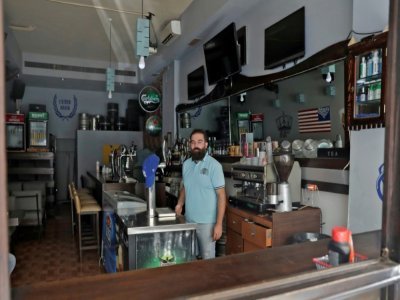 Ahmad el-Malla garde son bar ouvert malgré les coupures d'électricité, dans le quartier de Gemmayzé, à Beyrouth, le 20 août 2021 - ANWAR AMRO [AFP]